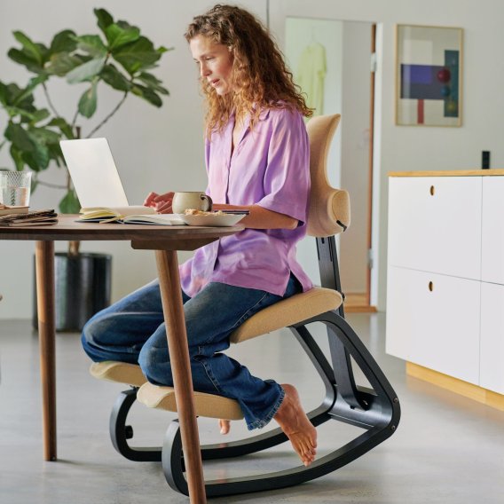 Frau auf einem Varier Thatsit arbeitend im Home-Office