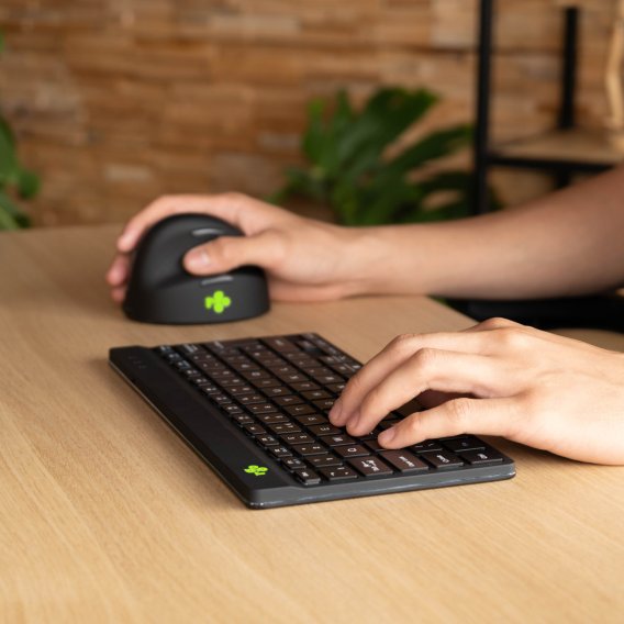 Die Compact Break kabellose Tastatur in schwarz von R-Go von der Seite betrachtet im Home-Office Setting mit einer Person in einem Anwendungsszenario