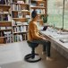 Mann ergonomisch sitzend auf dem Aeris Swopper im Arbeitszimmer.