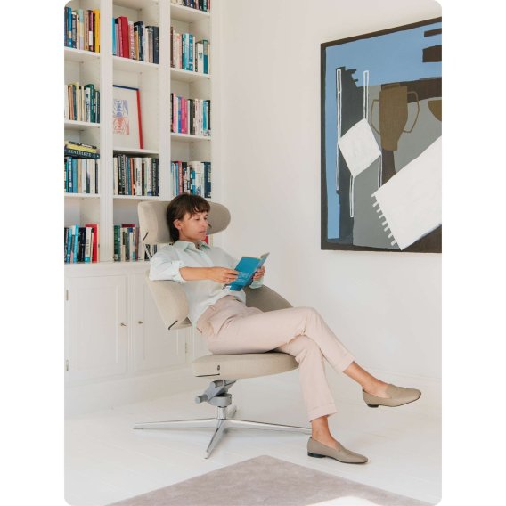 Eine Frau liest entspannt in einem Varier Peel Designer Loungesessel.