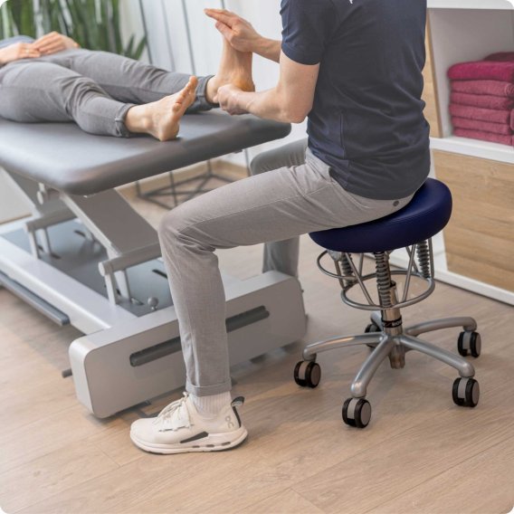 Haider Bioswing Foxter als Therapeutenhocker bei einer Fu&szlig;zonenmassage.